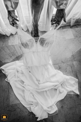 A black-and-white detail photograph from Tulum focuses on the bride stepping into her wedding dress, highlighting delicate fabric, graceful movement, and quiet anticipation as she prepares for the ceremony.
